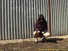 Hot chick peeing behind metallic offence